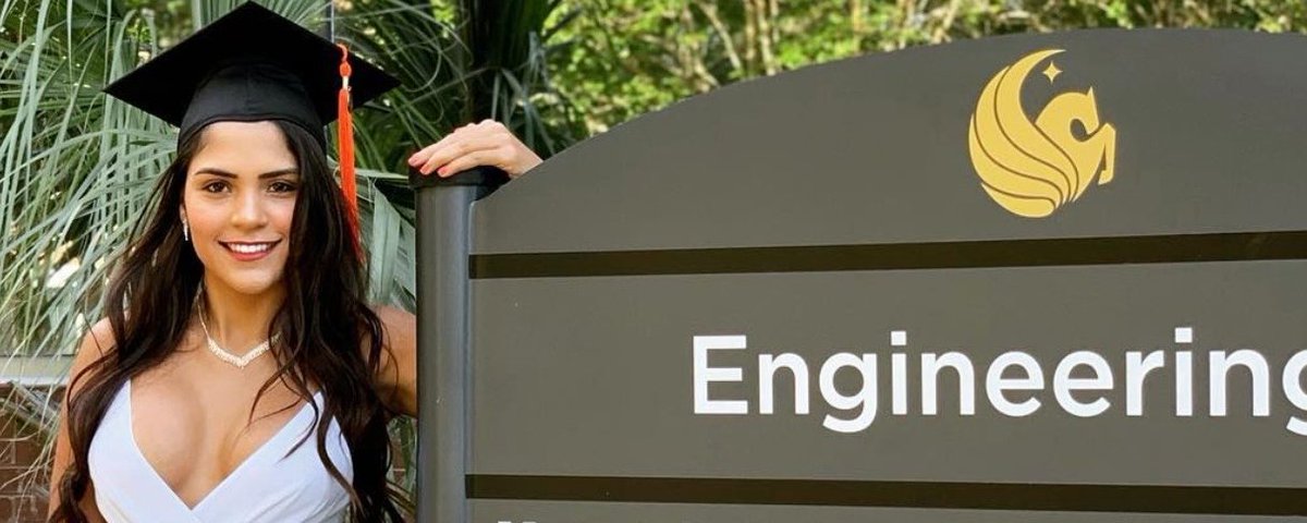 Eduarda in graduation attire beside an Engineering sign.