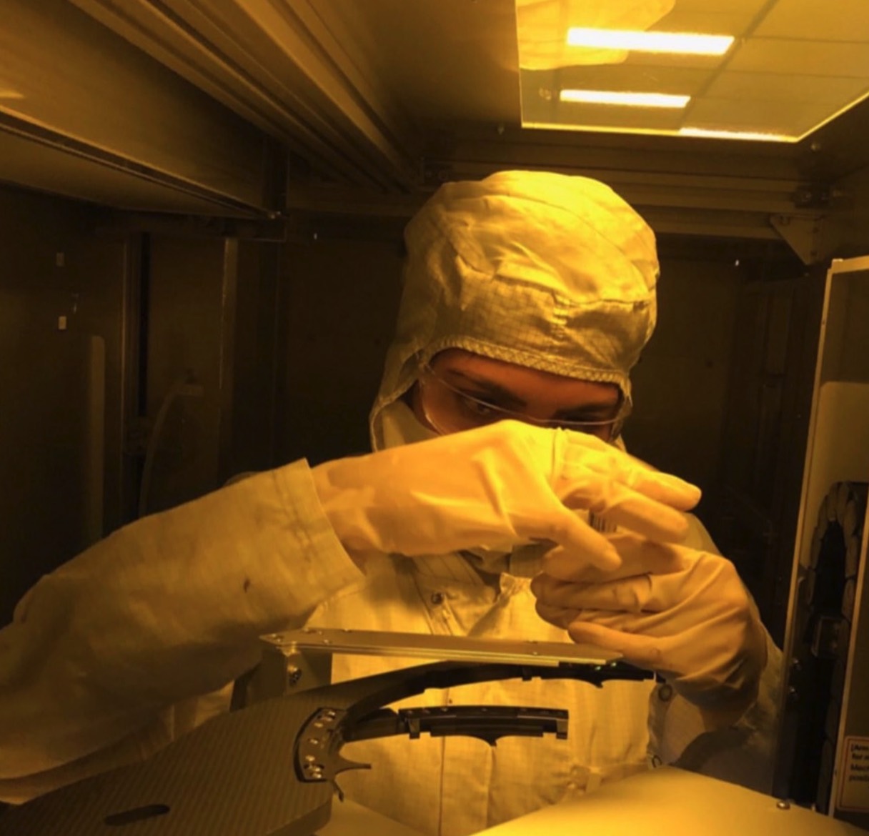 Working at a photolithography tool under the yellow light of the cleanroom at Texas Instruments